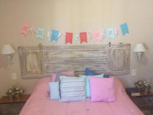 圣拉斐尔Maynumbí的一间卧室配有一张粉红色的床和一束枕头