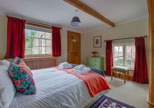 St Lawrence House的一间卧室配有一张带红色窗帘的大床