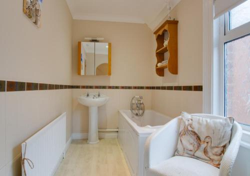 赫彻姆Staithe Cottage的带浴缸和盥洗盆的浴室