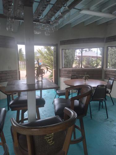 恩塞纳达港Casa Campo Rancho Villarino的客房设有2张桌子和椅子以及窗户。
