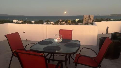 La VentanaCasa Arrecife, Beach is steps away! Fast internet, Private cozy room!的阳台上的桌子上放着一杯葡萄酒