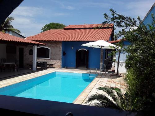 马里卡Casa de Veraneio的一座带游泳池和房子的别墅