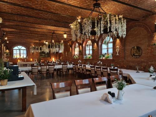 卢布林地区托马舒夫斯塔罗波尔斯卡酒店的一间设有白色桌椅的用餐室
