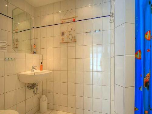 瓦尔内明德瓦尔内明德度假公寓的白色瓷砖浴室设有水槽和淋浴