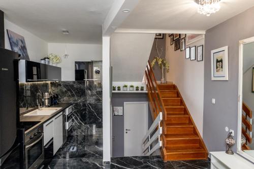 科尔丘拉Art & Gallery Vacation Home的一间铺有黑色大理石地板并设有一个楼梯的厨房