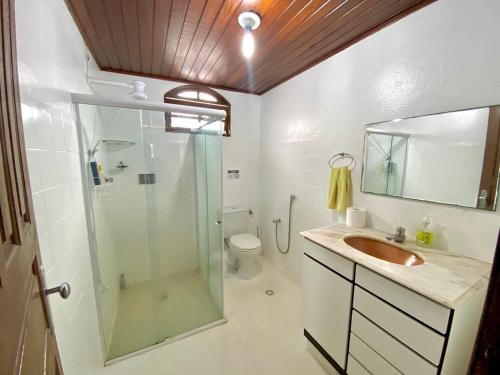 卡马萨里Casa Cantinho de Arembepe - Linda casa com piscina no litoral norte da Bahia的带淋浴、盥洗盆和卫生间的浴室