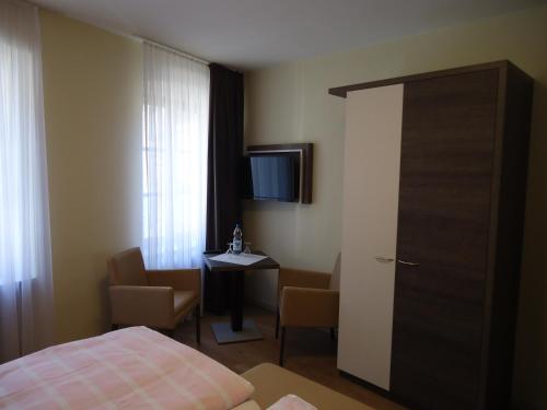 贝尔恩卡斯特尔-库斯湖沃旅馆的酒店客房设有床、桌子和电视。