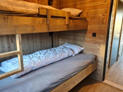 BudRorbu ved sjøen的小屋内设有一间带两张双层床的卧室