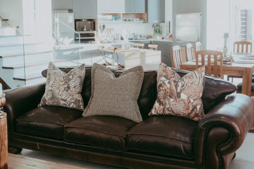 斯瓦科普蒙德Oceana View的客厅里配有带枕头的棕色皮沙发