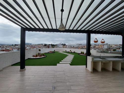 基多Departamento confortable en Quito的从带绿色庭院的建筑屋顶上欣赏美景