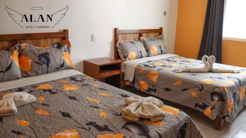 奇格纳瓦潘Hotel y Cabañas Alan的一间卧室配有两张带毛巾的床