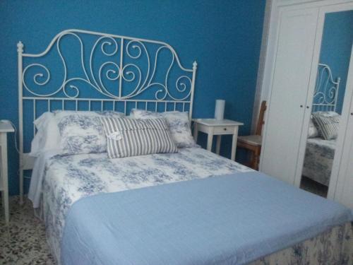 埃尔帕尔马Apartamentos Camping El Palmar的一间卧室配有一张蓝色墙壁的床