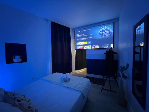 尼姆Roma Reva: design et home cinema的蓝色的房间,设有床和大屏幕