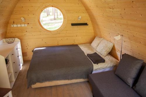 泰尔韦泰Meža namiņi Sprīdīši的小木屋内的卧室,配有床和窗户