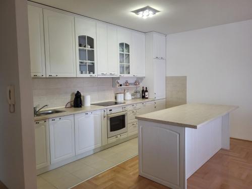 斯特鲁米察Luxury Central Apartment的白色的厨房配有白色的橱柜和台面