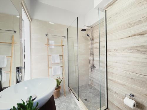 普拉塔尼亚斯米拉马尔公寓的带浴缸和玻璃淋浴间的浴室。