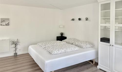 斯朗厄鲁普Cozy private annex near bathing lake and 30 min. from Copenhagen的白色的卧室设有床铺和白色的墙壁