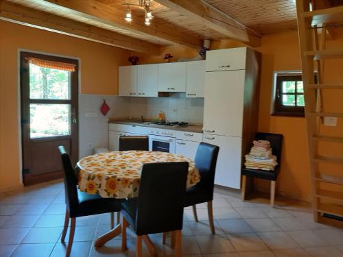 索卡Cottage Lepena的带桌椅的厨房以及带桌子和桌子的厨房。