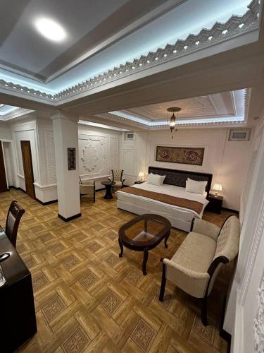 布哈拉SHAHRISTAN Plaza的一间卧室配有一张床、一张沙发和一张桌子