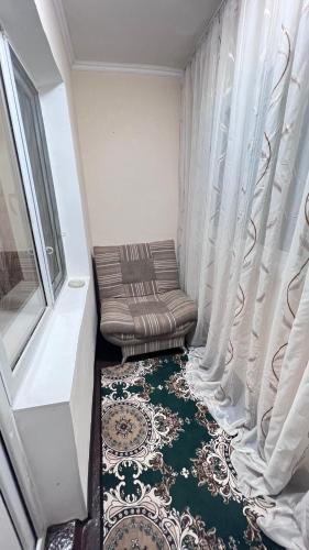 塔拉兹Чистая и уютная квартира в 6-ом микрорайоне的小房间设有椅子和窗户