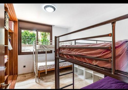 皮内达德马尔Casa rustica con piscina y jardin的一间卧室设有两张双层床和一扇窗户。