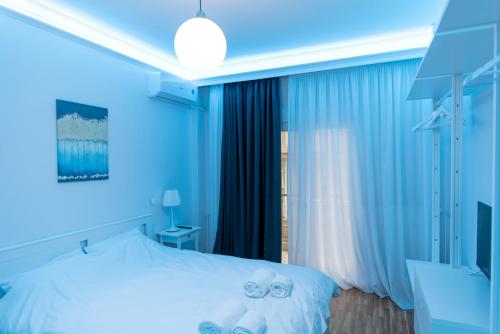 塞萨洛尼基Athina Pantheon Mitropoleos的蓝色卧室,配有带毛巾的床