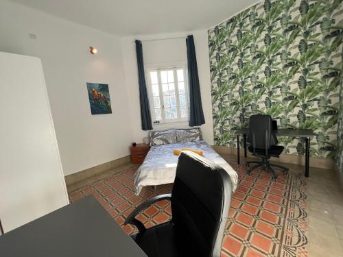 大加那利岛拉斯帕尔马斯CoLiving Villa Brasil的客房设有一张床、一张桌子和一张桌子。