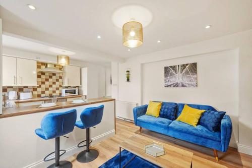 KentSleeps 5 - Large Garden - Wifi的一间带蓝色沙发的客厅和一间厨房