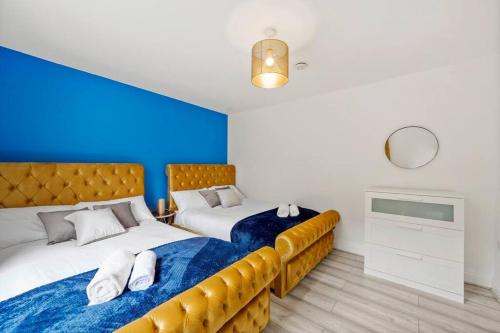 KentSleeps 5 - Large Garden - Wifi的一间卧室设有两张床和蓝色的墙壁