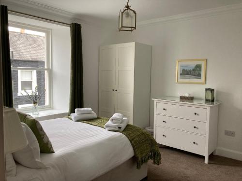 柯库布里Serendipity的一间卧室配有一张床、一个梳妆台和一扇窗户。
