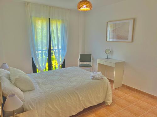 塞埃Apartamento Ultreia - Estorde的一间卧室配有一张床、一个窗口和一张书桌