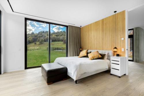 箭镇Countryside Escape Arrowtown的一间卧室设有一张床和一个大窗户