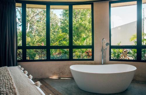 图卢姆Round Villa Private Pool & Jungle rooftop 2A的窗户前设有大浴缸的浴室