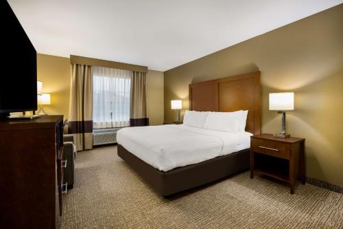 摩根城摩根城康福特茵套房酒店的配有一张床和一台平面电视的酒店客房