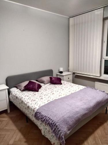 华沙ToTuToTam的一间卧室配有一张带紫色枕头的大床