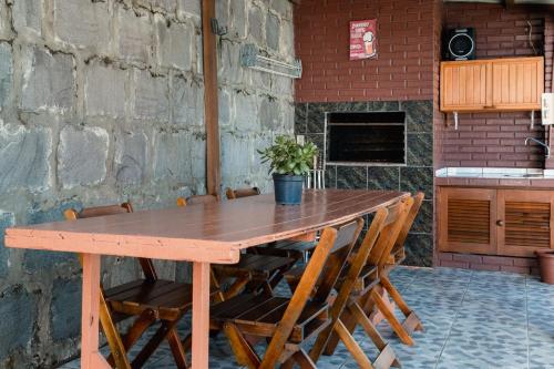 格拉玛多Casa da bela Vista的砖墙旁的一张木桌和椅子
