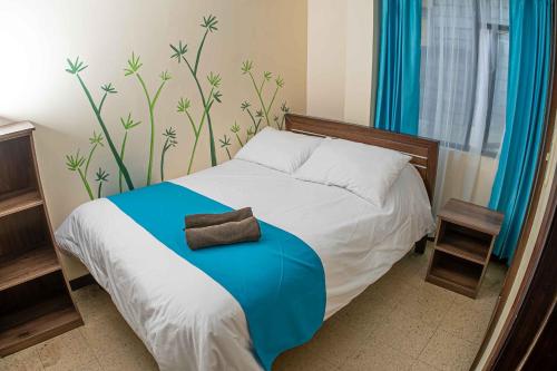 巴尼奥斯Hotel Tungurahua的一间卧室配有一张带蓝色毯子的床