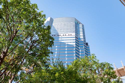 东京东京品川诗颖洲际酒店的一座高大的玻璃建筑,前面有树木