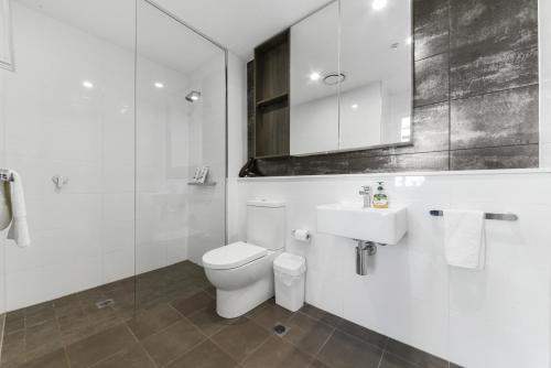 悉尼Broad Land Premium Apartments Chatswood Sydney的白色的浴室设有卫生间和水槽。