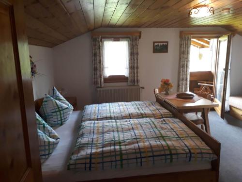 柯尼希斯湖畔舍瑙Haus Widlbrand的一间卧室配有一张大床和一张桌子