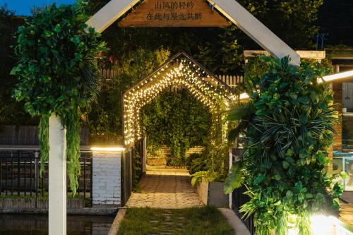 怀柔旅约长城民宿的夜间花园中带灯光的拱门