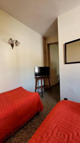 特尔马斯德里奥翁多Departamento的客房设有两张床和一张书桌及一台电视。