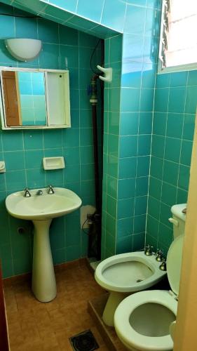 特尔马斯德里奥翁多Departamento的绿色瓷砖浴室设有卫生间和水槽