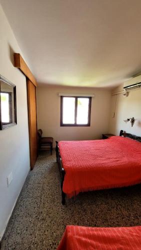 特尔马斯德里奥翁多Departamento的一间卧室设有两张带红色床单的床和窗户。