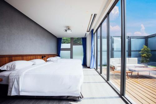 基隆Hotel BEGINS 倉箱蜜境文旅的一间带大床的卧室和一个阳台