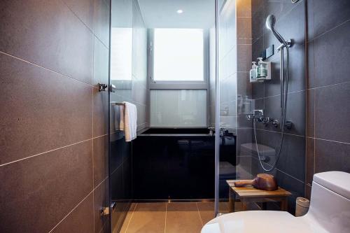 基隆Hotel BEGINS 倉箱蜜境文旅的带淋浴、卫生间和窗户的浴室