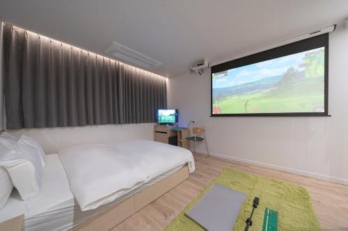 大田The Hyoosik Aank Hotel Daejeon Yooseong Hot Spring 2nd Branch的一间卧室配有一张床和一台平面电视