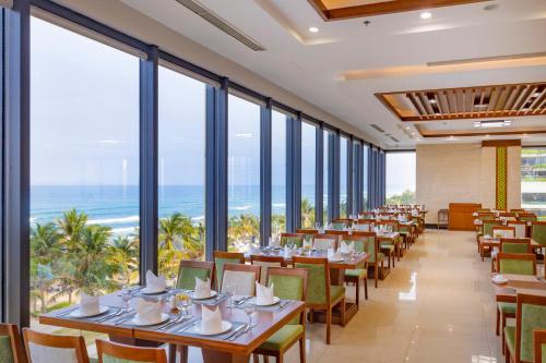 岘港Rosamia Da Nang Hotel的一间设有桌椅的海洋餐厅
