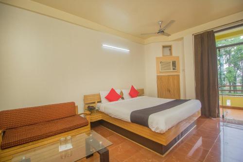 Ingrāj BāzārFlagship 43145 Mayaban Resort的一间卧室配有一张床、一张长凳和一个窗户。