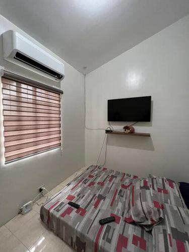 Spacious & Cozy 3BR House w/WIFI的一间卧室配有一张床和一台平面电视